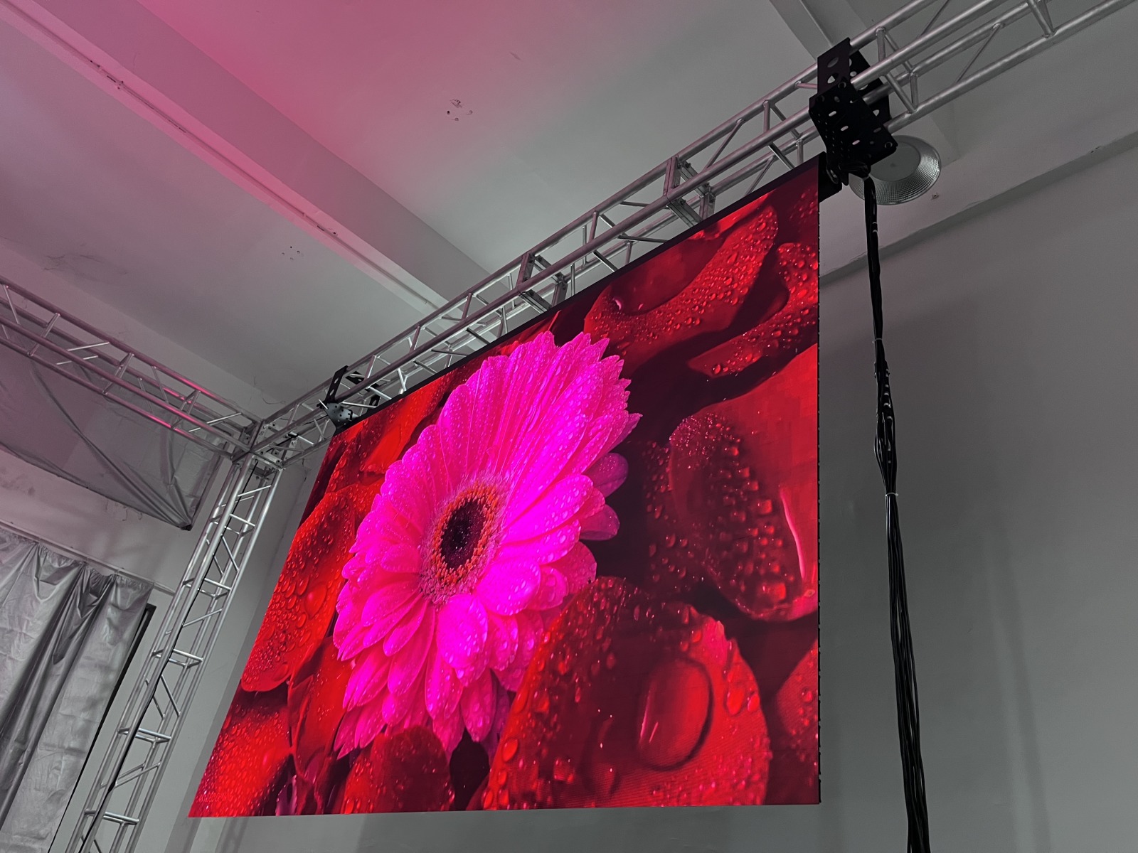 Rolling LED wall deployed from ceiling truss with vivid floral content