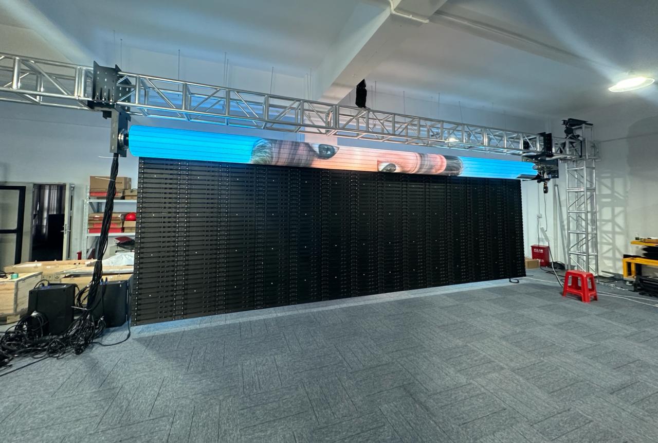 Rolling LED wall partially retracted into truss-mounted roller